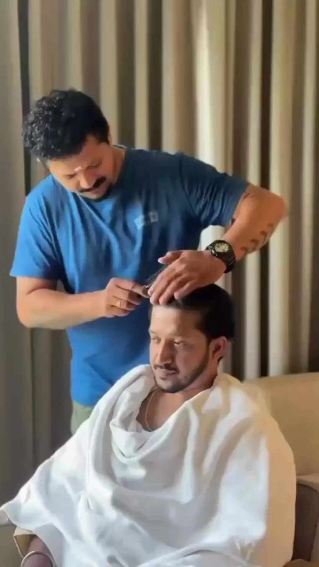 A Gents Camp barber cutting a seated customer’s hair at the chair