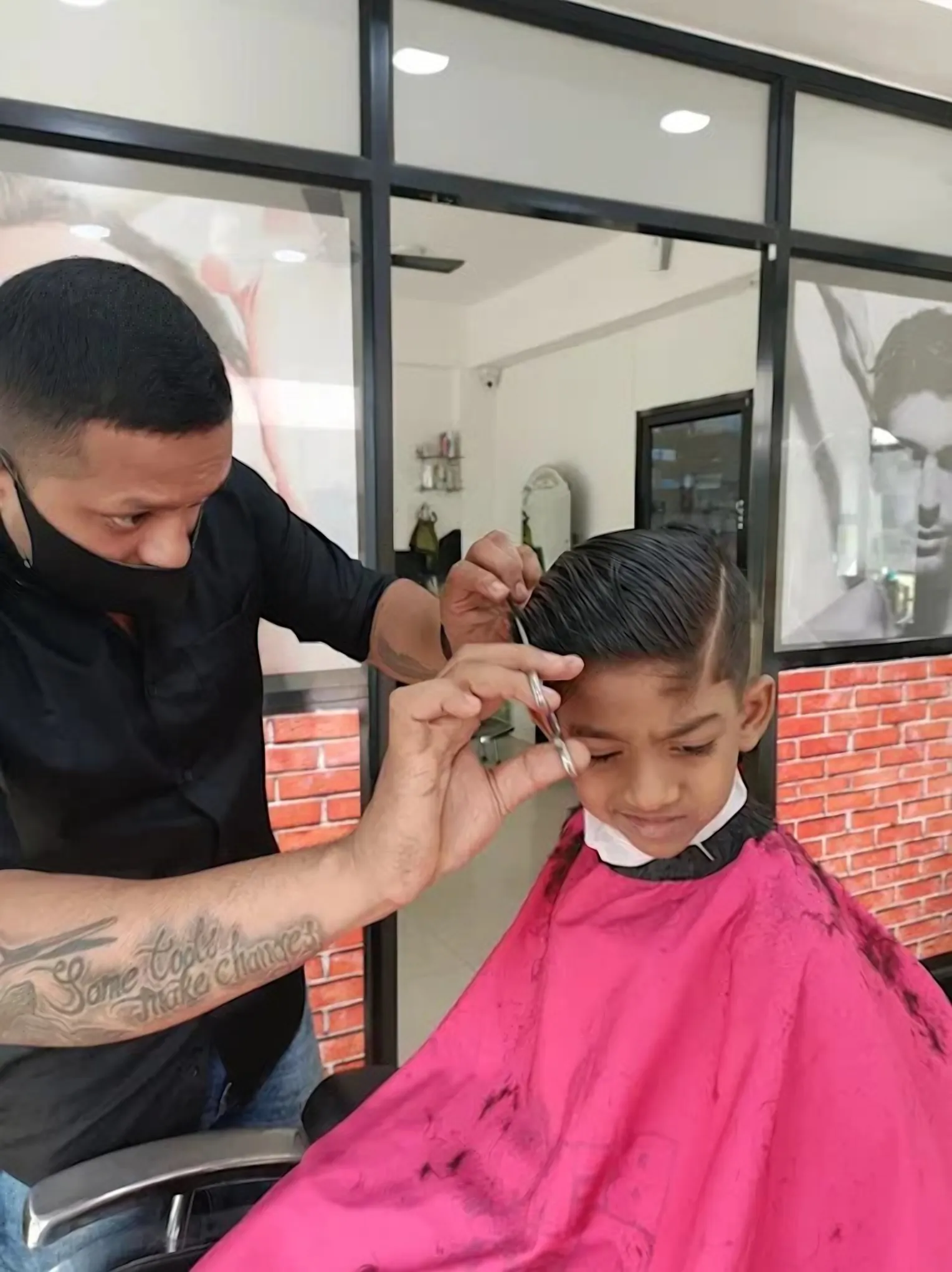A child having his hair cut in the barber’s chair