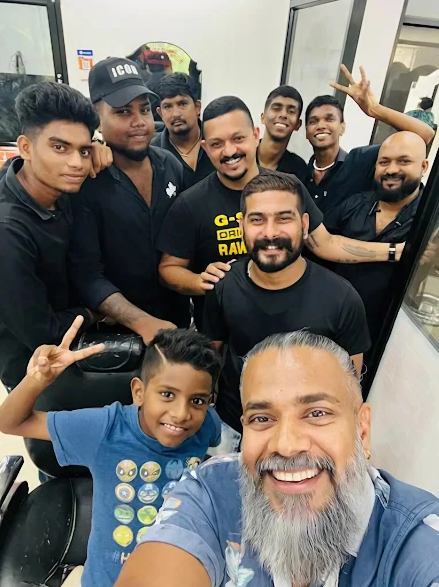 Barbers and a young customer in the mirror at Gents Camp
